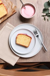 Photo of Tasty sweet cake with cream served on wooden table, flat lay