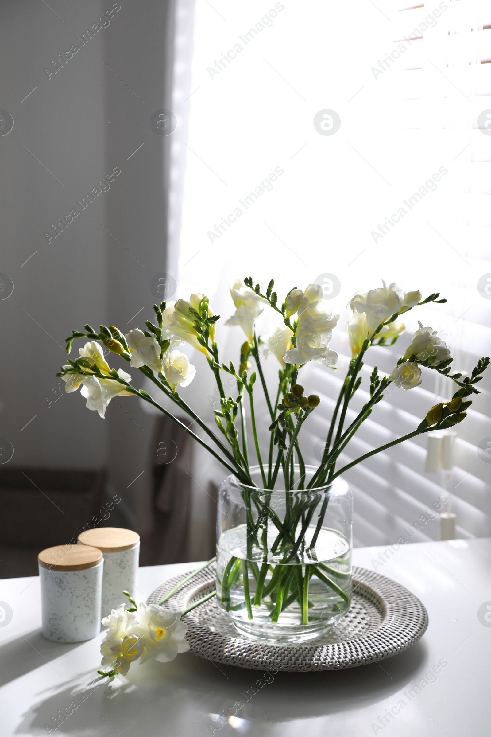 Photo of Beautiful spring freesia flowers on table in room