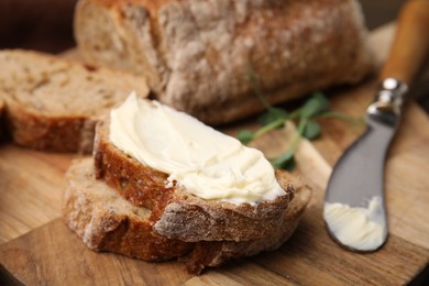 Photo of Slices of tasty bread with butter and knife on wooden board, closeup. Space for text