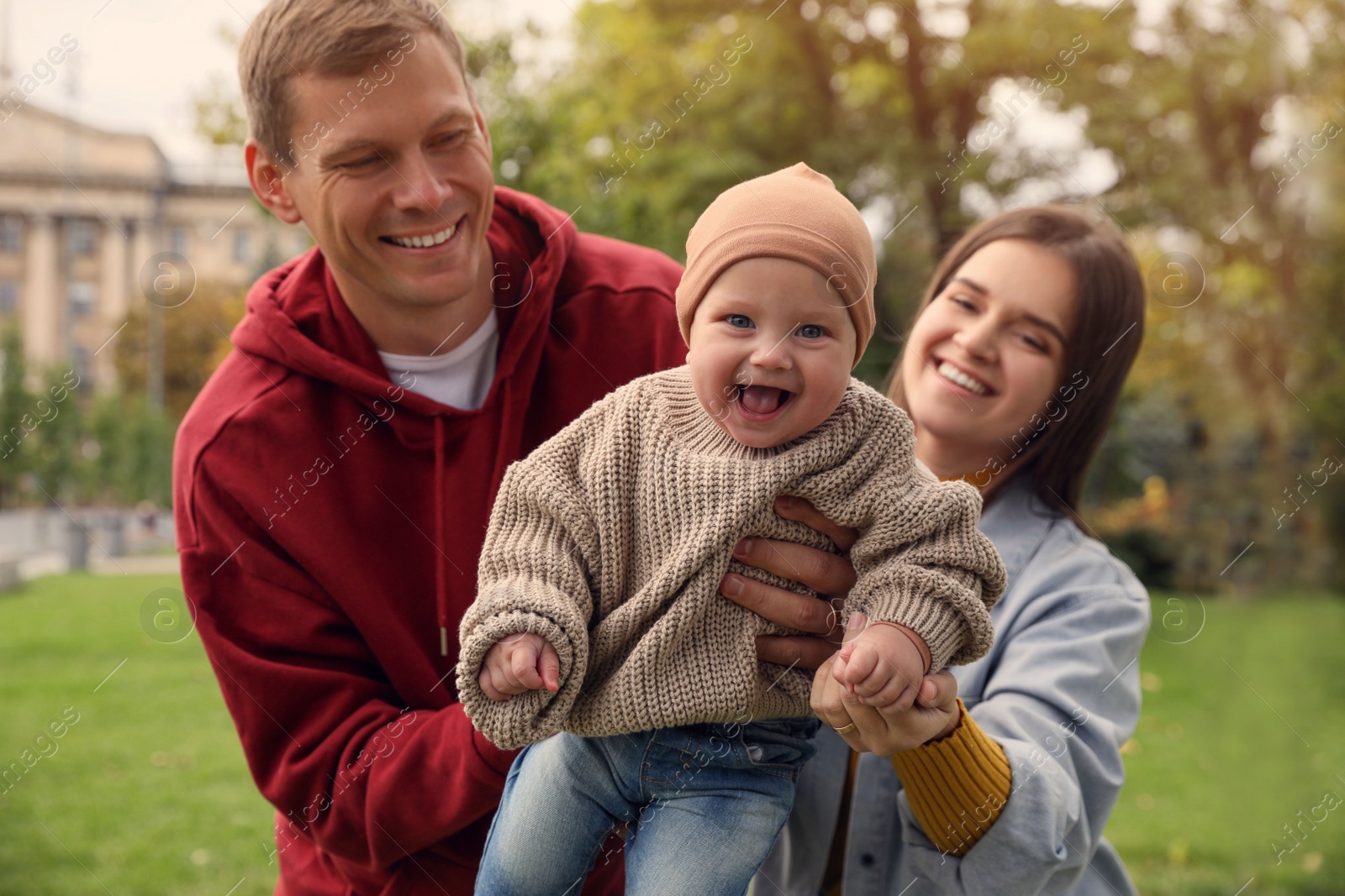 Photo of Happy parents with their adorable baby walking in park