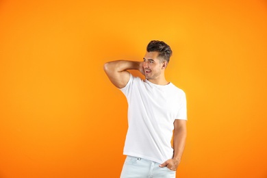 Young man in t-shirt on color background. Mockup for design