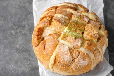 Photo of Freshly baked bread with tofu cheese on grey table, closeup