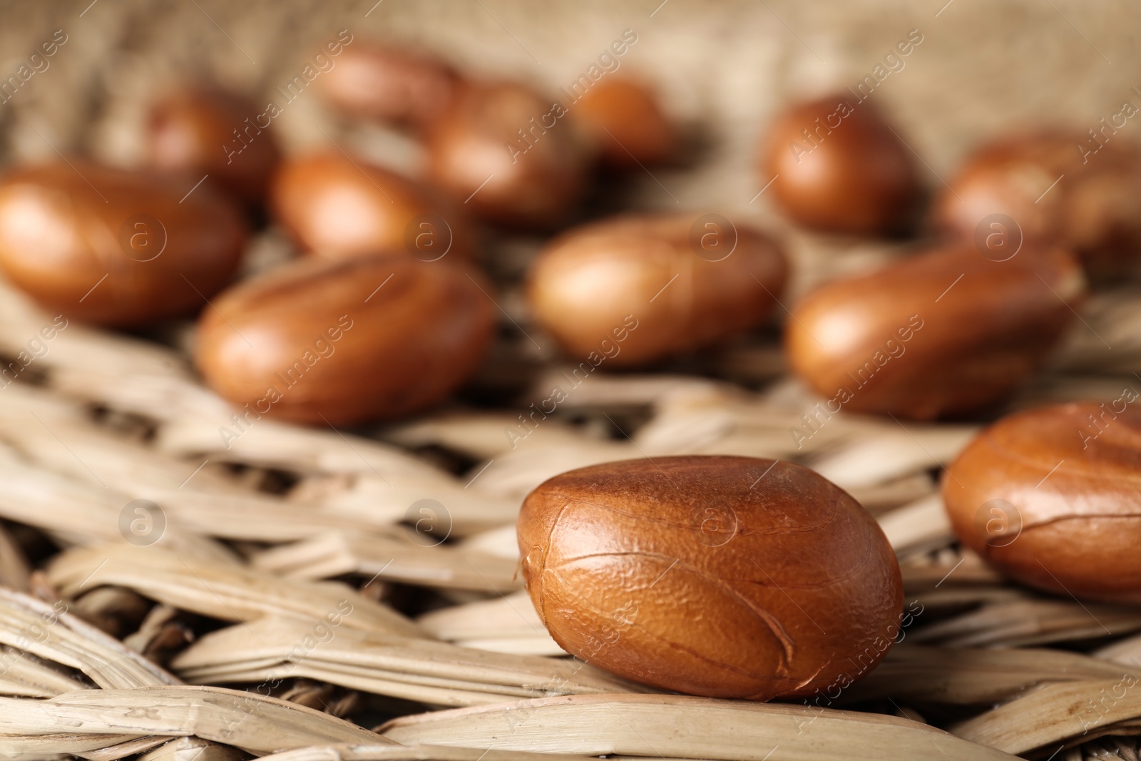 Photo of Many raw jackfruit seeds on wicker mat, closeup