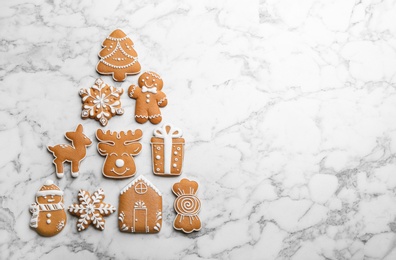 Christmas tree shape made of delicious gingerbread cookies on white marble table, flat lay. Space for text