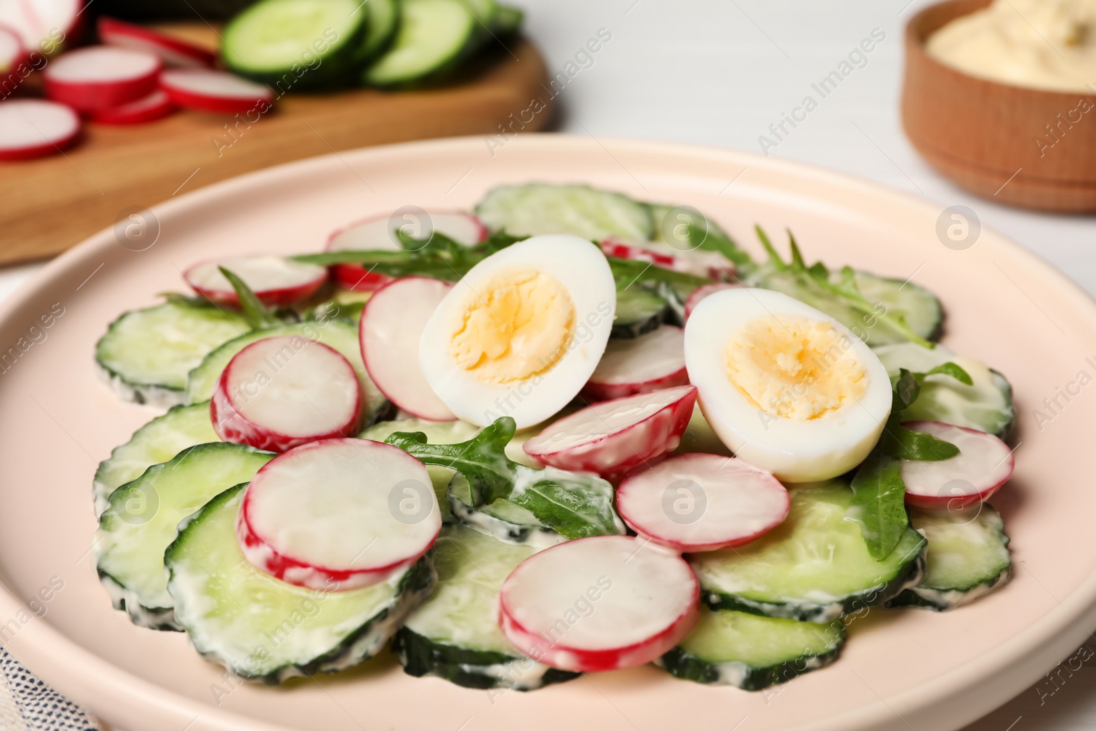 Photo of Tasty fresh salad with cucumber on white table, closeup