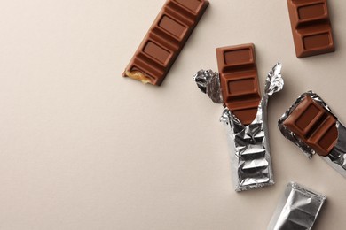 Tasty chocolate bars on light background, flat lay. Space for text