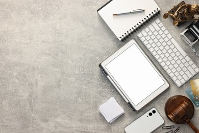 Flat lay composition with modern tablet on light gray textured table. Space for text