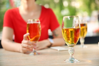 Glass with cold beer and blurred woman on background
