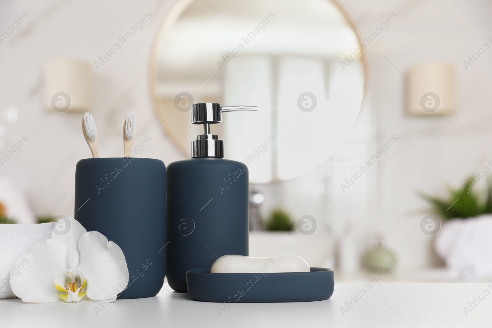 Image of Bath accessories. Different personal care products and flower on white table in bathroom, space for text