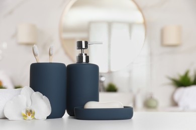 Image of Bath accessories. Different personal care products and flower on white table in bathroom, space for text