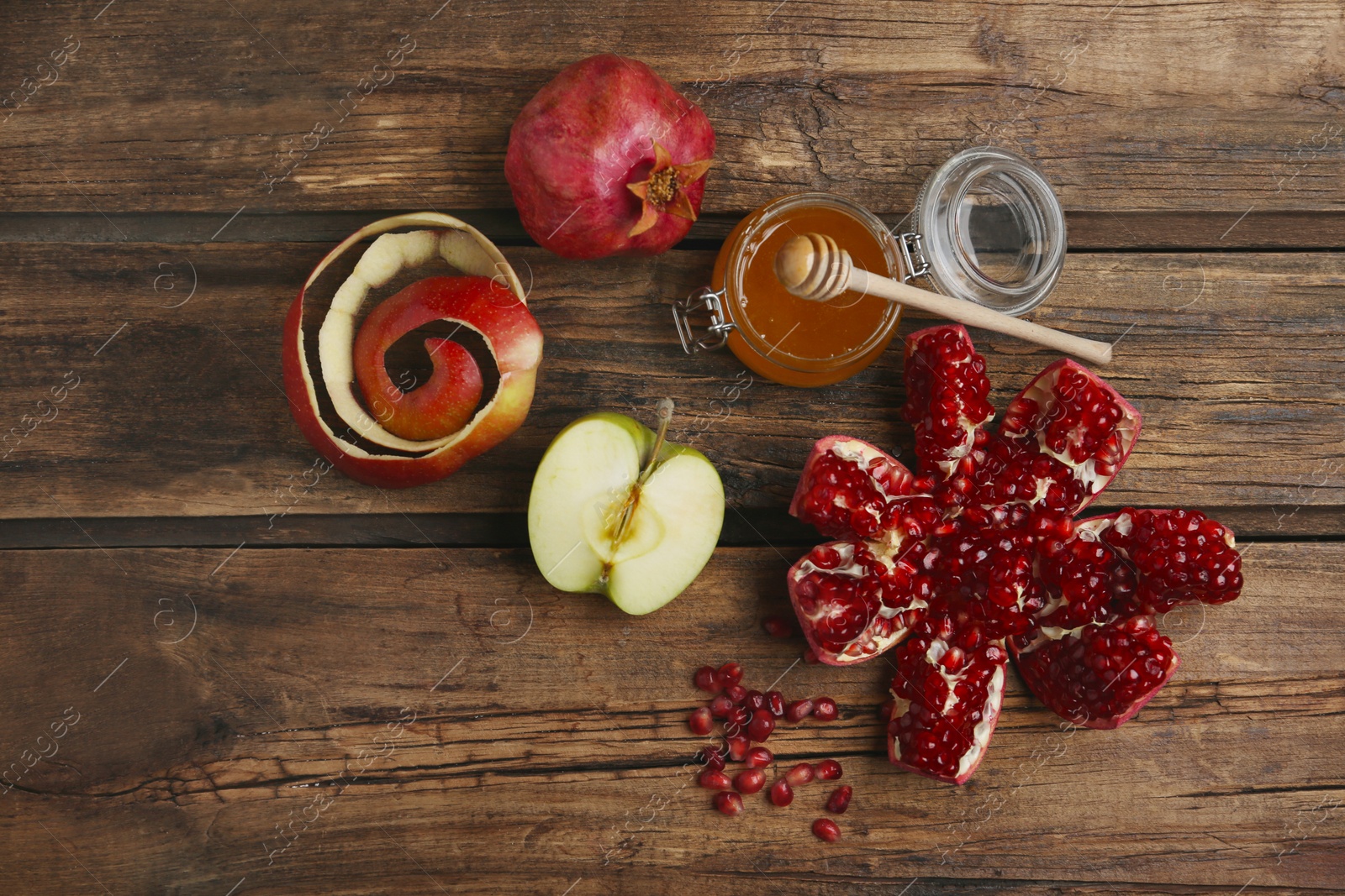 Photo of Honey, apples and pomegranate on wooden table, flat lay. Rosh Hashanah holiday