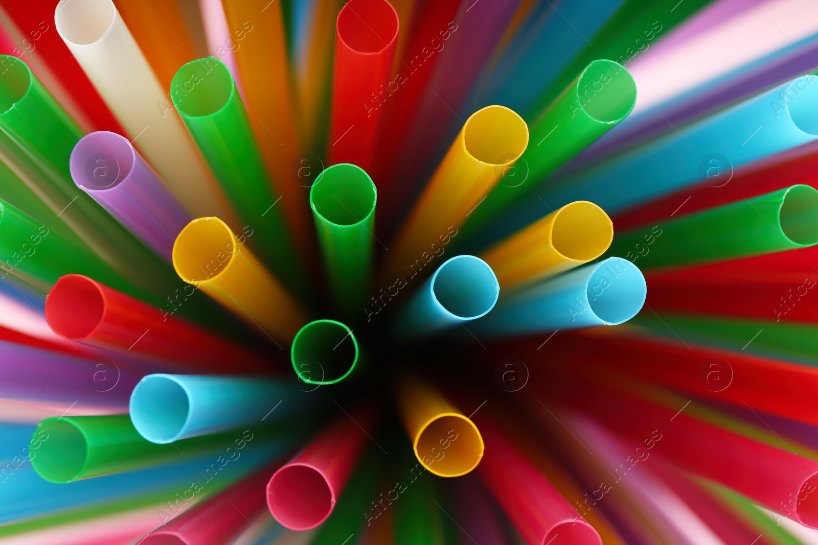 Photo of Heap of colorful plastic straws for drinks as background, closeup