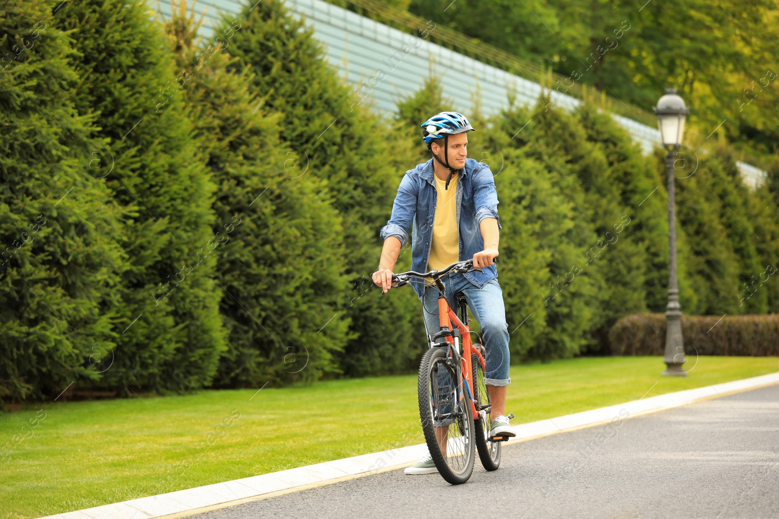 Photo of Young man in helmet riding bike outdoors