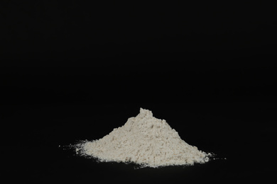 Photo of Pile of white flour on black background