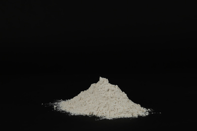 Pile of white flour on black background