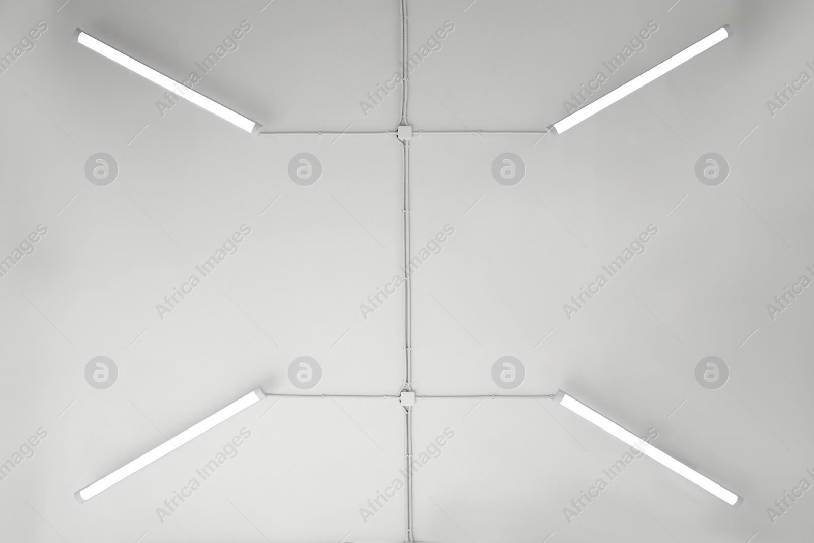 Photo of White ceiling with modern lighting in room, bottom view