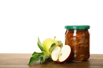 Photo of Tasty apple jam in glass jar and fresh fruits on wooden table against white background