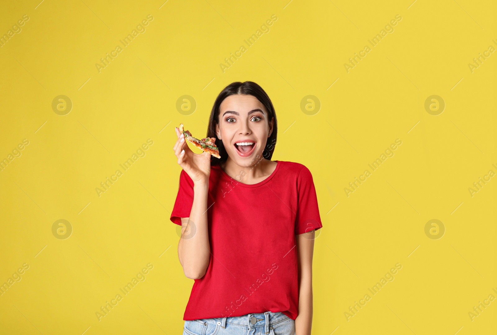 Photo of Emotional woman with tasty pizza on yellow background