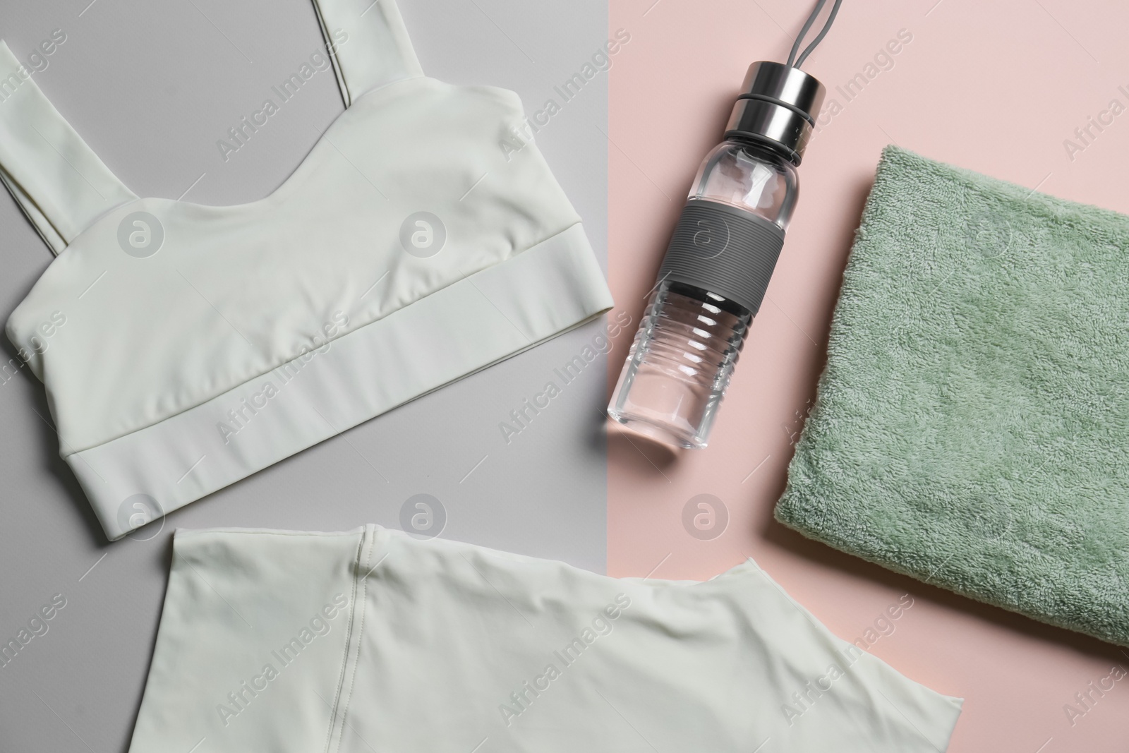 Photo of Yoga sportswear, bottle of water and towel on color background, flat lay