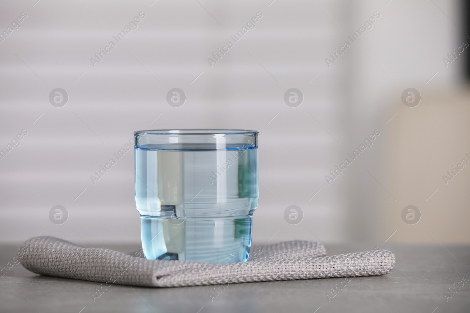 Photo of Glass of pure water on grey table indoors, space for text