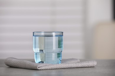 Glass of pure water on grey table indoors, space for text