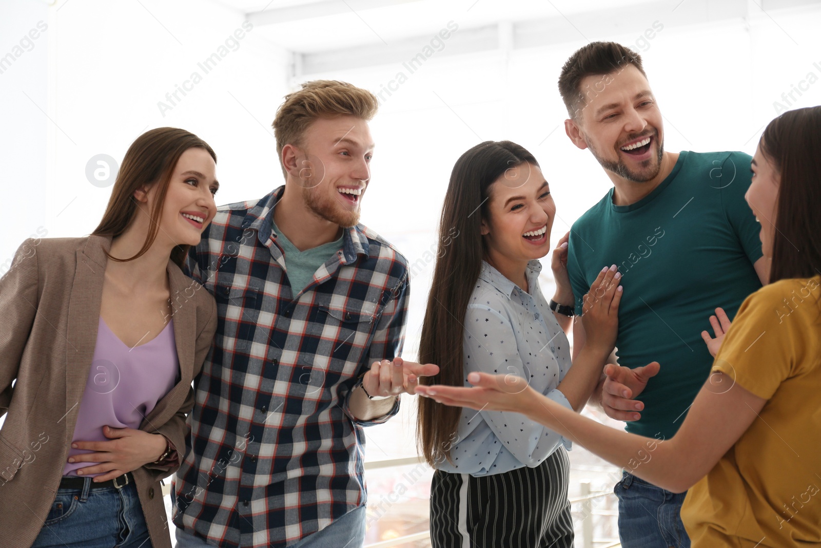 Photo of Group of happy people talking in light room