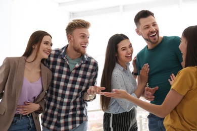 Group of happy people talking in light room