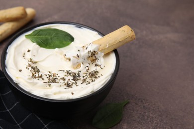 Photo of Delicious cream cheese with grissini stick and spices on grey table, closeup. Space for text