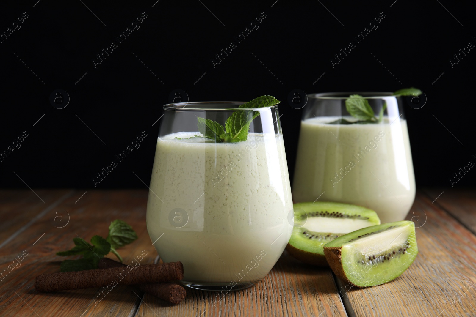 Photo of Tasty milk shake with kiwi on wooden table