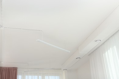 White ceiling with modern lighting in office