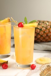 Photo of Tasty pineapple cocktail with mint and cherry on table