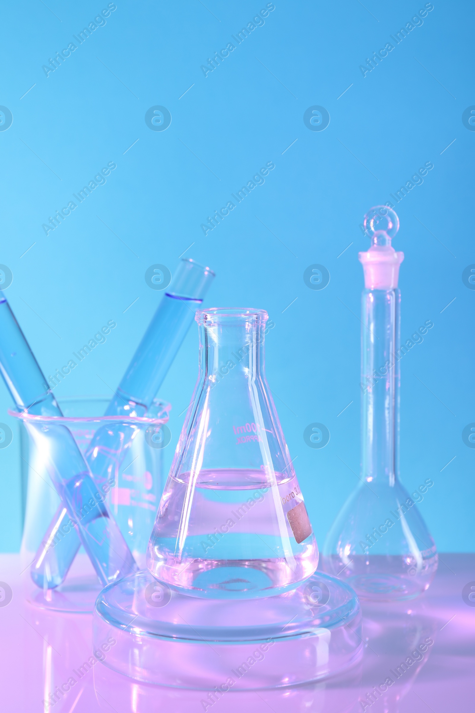 Photo of Laboratory analysis. Different glassware on table against light blue background