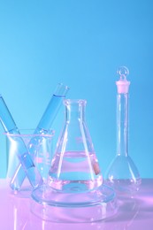 Photo of Laboratory analysis. Different glassware on table against light blue background