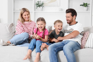 Photo of Happy family having fun together on sofa at home