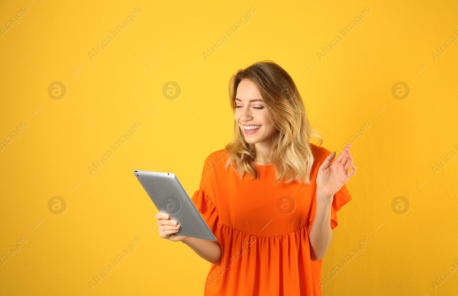 Photo of Woman using tablet for video chat on color background. Space for text