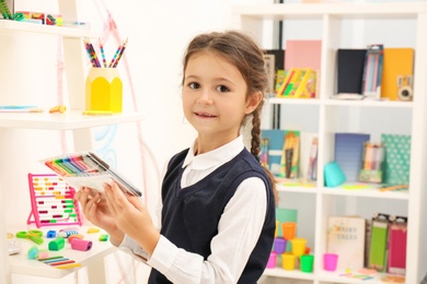 Cute child choosing school stationery in store