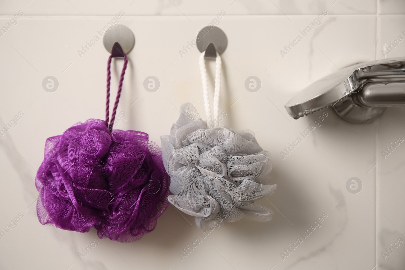 Photo of Shower puffs hanging near faucet in bathroom