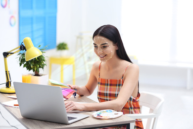 Facial recognition system. Woman using laptop in office 