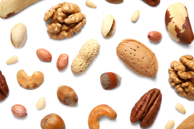 Different delicious nuts on white background, flat lay