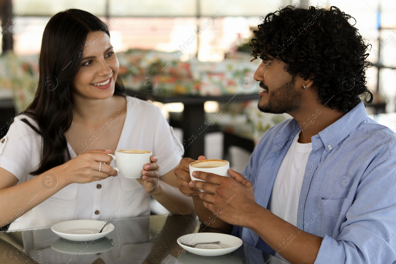 Photo of International dating. Happy couple enjoying tasty coffee in cafe