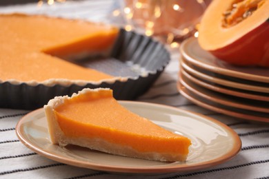 Photo of Plate with piece of fresh homemade pumpkin pie on table