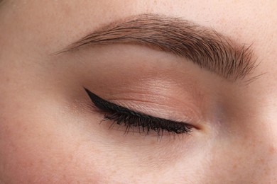 Makeup product. Woman with black eyeliner and beautiful eyebrow, closeup