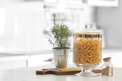 Raw pasta on wooden table in modern kitchen