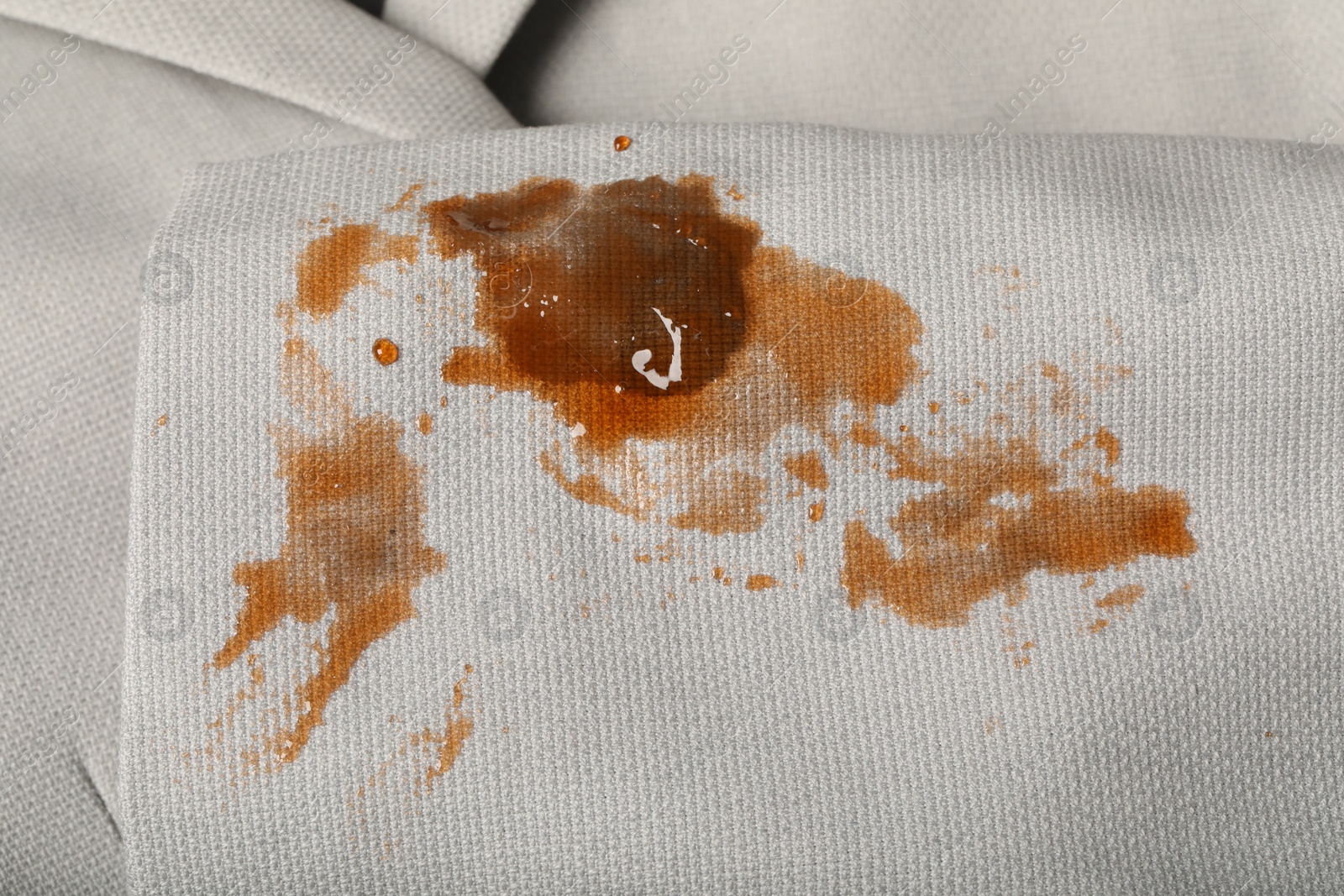 Photo of Dirty jacket with stain of coffee as background, closeup