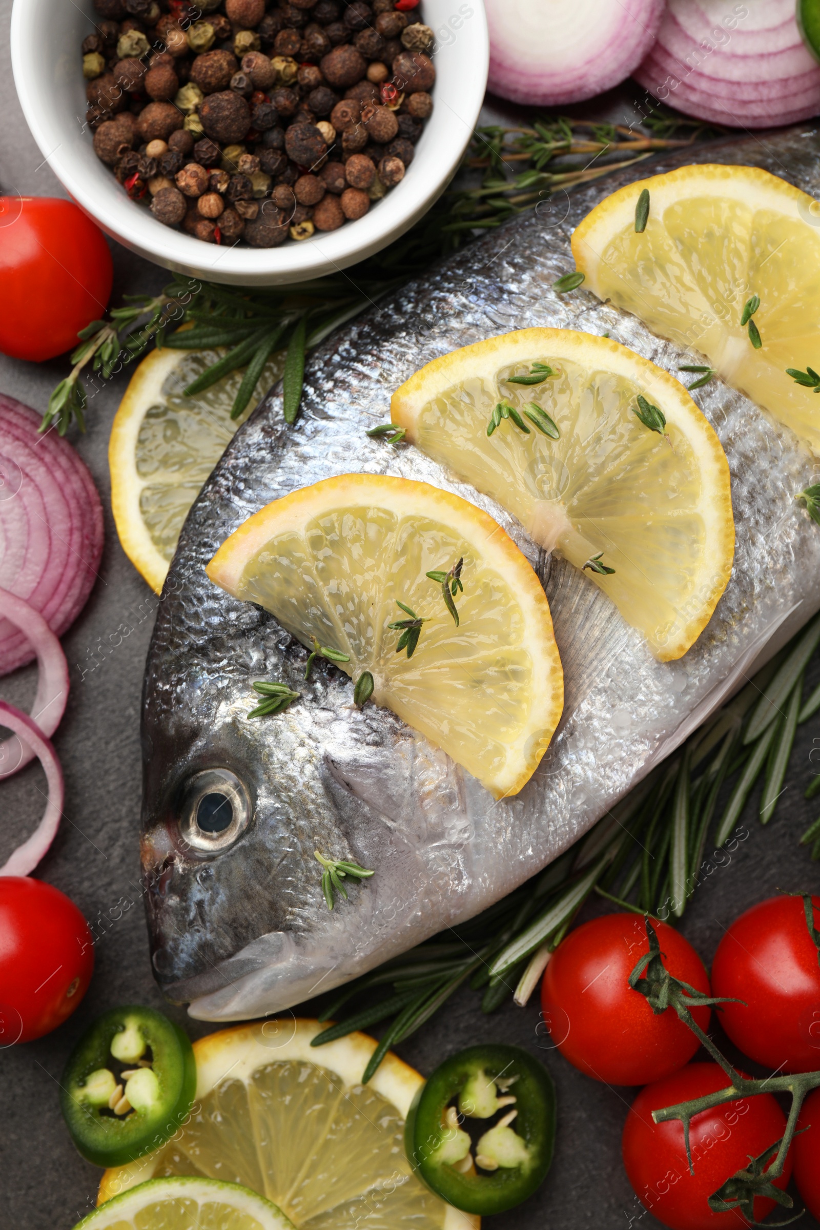 Photo of Fresh dorado fish and spices on black table, flat lay