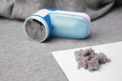 Photo of Modern fabric shaver and lint on light grey cloth