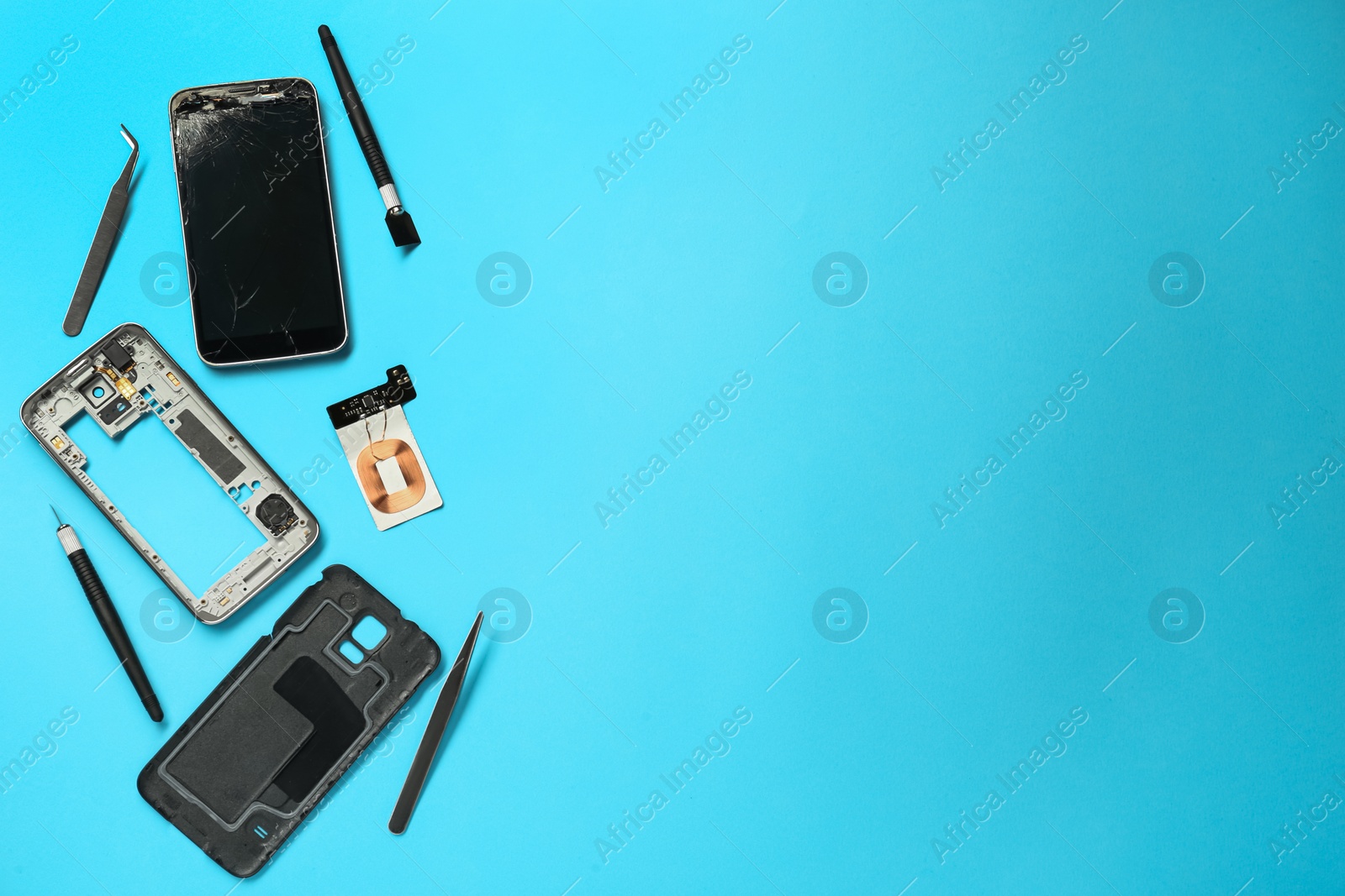 Photo of Damaged smartphone and repair tools on light blue background, flat lay. Space for text