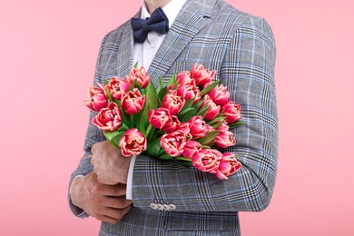 Photo of Man with beautiful bouquet on pink background, closeup
