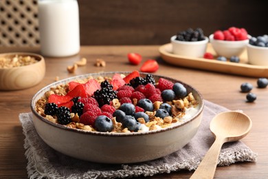 Photo of Healthy muesli served with berries on wooden table