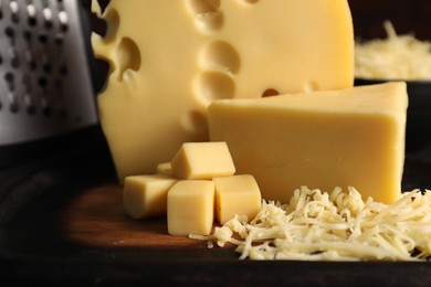 Grated, cut cheese and grater on table, closeup